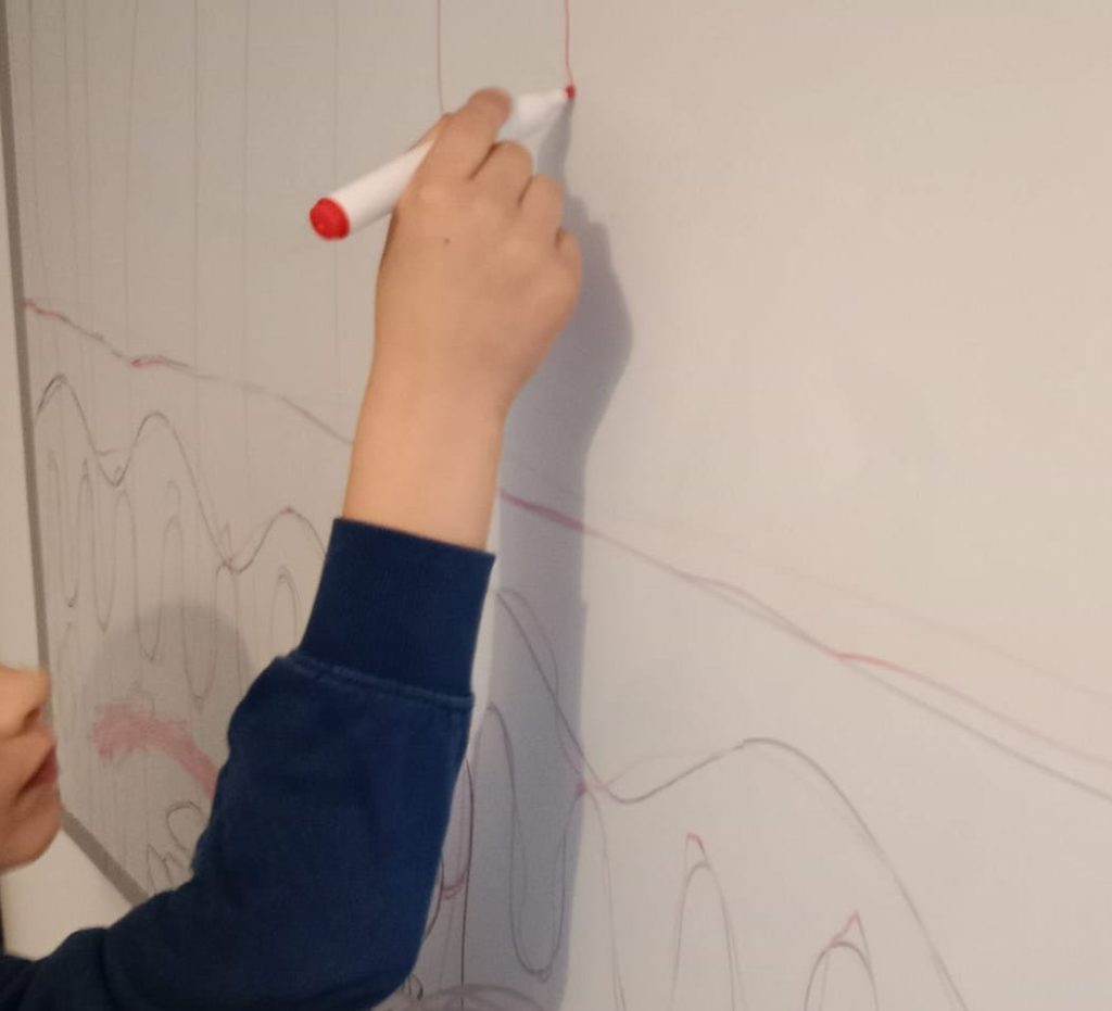 Enfant en séance de rééducation de l'écriture chez une graphothérapeute